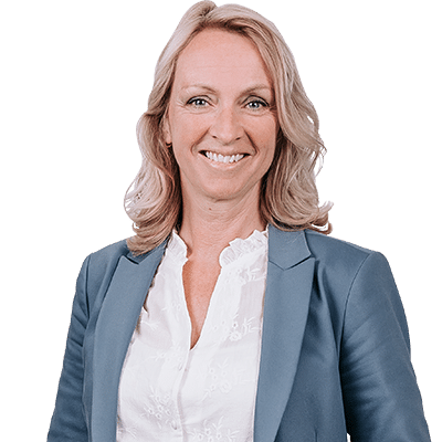 Vriendelijke professionele vrouw met blond haar in een blauw colbert en witte blouse, glimlachend en recht in de camera kijkend, tegen een neutrale achtergrond.